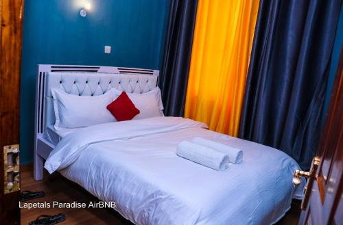 sypialnia z białym łóżkiem z 2 poduszkami w obiekcie Lapetals-Paradise-3bedrooms-ABNB machakos town w mieście Machakos