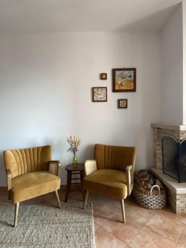 a living room with two chairs and a fireplace at Duplex nuovo e grazioso in Capracotta