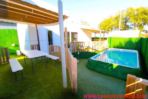 a patio with a pool and a table and chairs at Lodges de cedros in Setúbal
