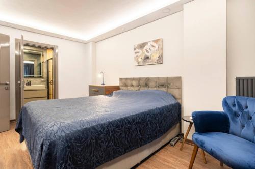 um quarto com uma cama e uma cadeira azul em Luxury apartment in the heart of Nisantasi em Istambul