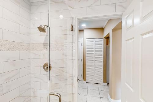 Home near the beach & golf with inviting patio, fireplace, AC, & washer/dryer في فرناندينا بيتش: حمام أبيض مع دش مع باب زجاجي