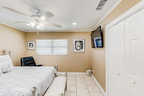 Home near the beach & golf with inviting patio, fireplace, AC, & washer/dryer في فرناندينا بيتش: غرفة نوم بها سرير ومروحة سقف