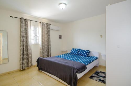 un dormitorio con una cama y una ventana en Tali & Tani Apartment, en Willemstad