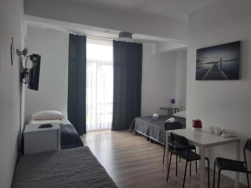 Schlafzimmer mit einem Bett und einem Tisch mit Stühlen in der Unterkunft Figaro Apartaments in Gdynia