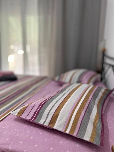 2 Betten mit rosa Bettwäsche und einem Kissen darauf in der Unterkunft Apartment Alex in Athen