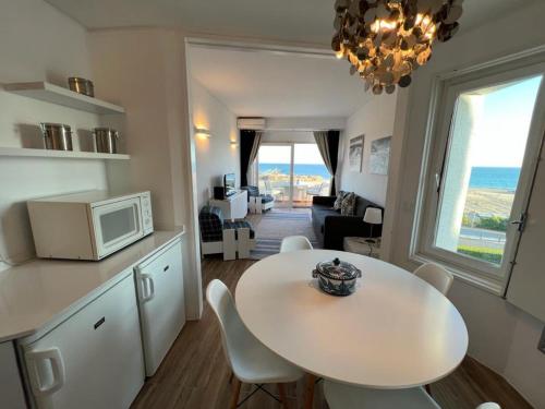 een keuken en een woonkamer met een tafel en een magnetron bij welkome OCEAN BREEZE in Portimão