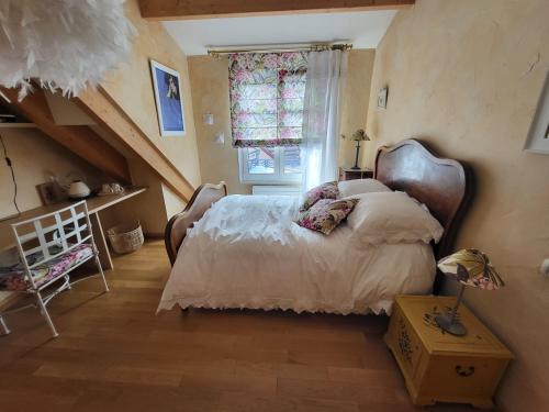 a bedroom with a large bed and a window at Poésie en partage in Giromagny