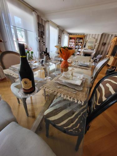 a dining room table with a bottle of wine on it at Poésie en partage in Giromagny