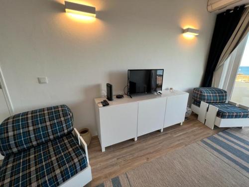 a living room with a tv and two chairs at welkome OCEAN BREEZE in Portimão
