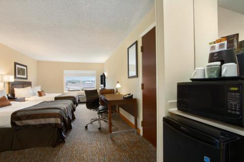 a hotel room with two beds and a desk at Wingate by Wyndham - Chattanooga in Chattanooga