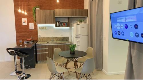 a kitchen with a table and chairs and a tv at AP1203 . CONFORTO, PRATICIDADE E LOCALIZAÇÃO in Maringá