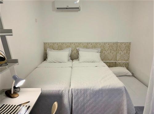 a small bedroom with two beds and a desk at AP1203 . CONFORTO, PRATICIDADE E LOCALIZAÇÃO in Maringá