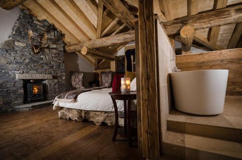a bedroom with a bed and a fireplace at Black Diamond Sainte Foy Chalets in Sainte-Foy-Tarentaise