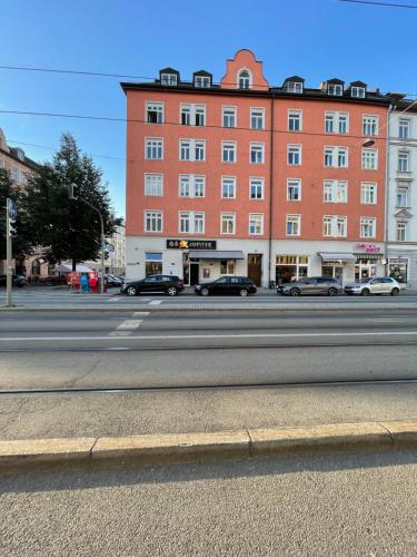 een groot gebouw met auto's geparkeerd aan de kant van een straat bij Hause münchen comfort! in München