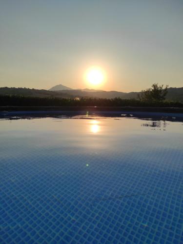 een zwembad met zonsondergang op de achtergrond bij Casa vacanze in famiglia in San Leucio del Sannio