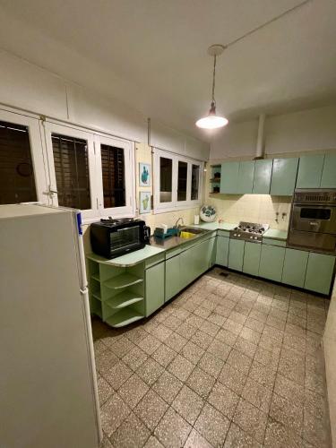 uma cozinha com armários verdes e um frigorífico em Casa en Alquiler Margarita em San Fernando del Valle de Catamarca