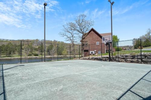 an empty basketball court with a fence and a barn at Local Hero Lodge in Reeds Spring