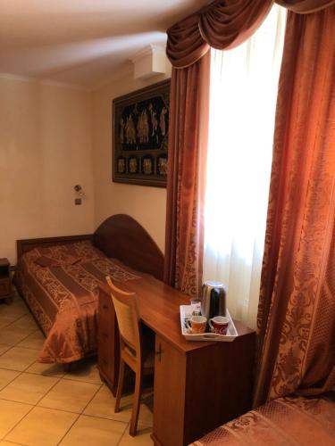 1 dormitorio con cama, escritorio y ventana en Hotel Ajka 1, en Ajka