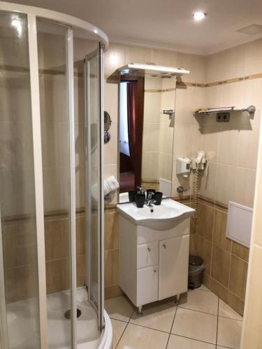 uma casa de banho com um chuveiro e um lavatório. em Hotel Ajka 1 em Ajka
