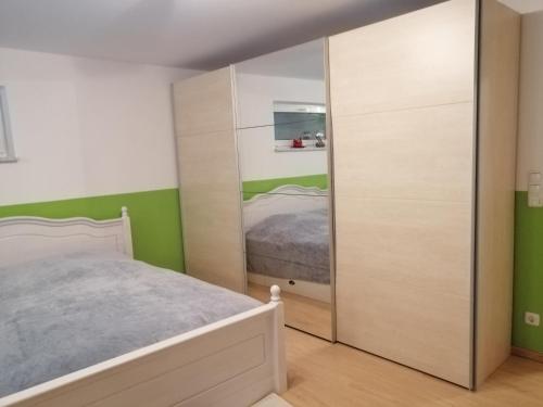 1 dormitorio con cama y espejo grande en Ferienwohnung Borger, en Sauerlach