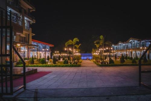 a courtyard at night with buildings and palm trees at Hotel Quick20 And Riverside Pvt. Ltd. in Amlekhganj