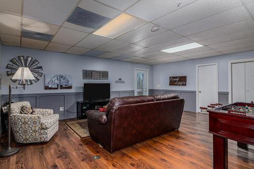 a living room with a leather couch and a tv at Ozark Outdoor Legacy in Ridgedale