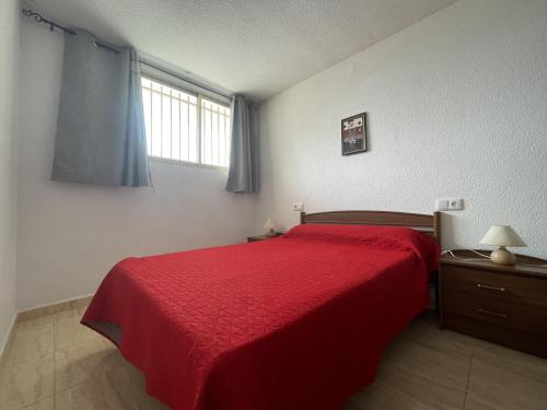 ペニスコラにあるPeñismar I Dのベッドルーム1室(赤いベッド1台、窓付)