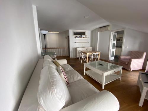 sala de estar con sofá blanco y mesa en Apartamentos Ceo ciudad en Ronda