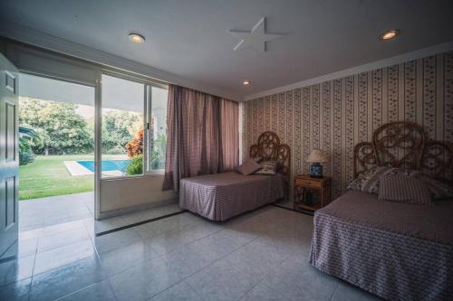 1 Schlafzimmer mit 2 Betten und Poolblick in der Unterkunft Preciosa Casa en Yautepec, Morelos. in Yautepec de Zaragoza