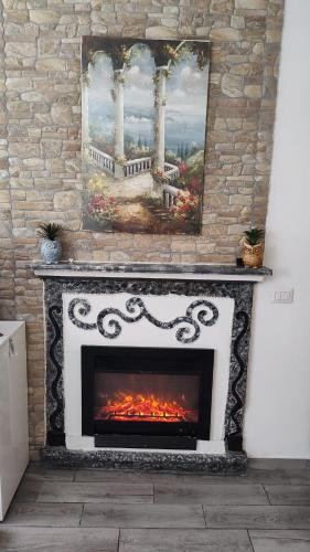 a fireplace in a room with a painting on the wall at Appartamento nel cuore di Varese in Varese