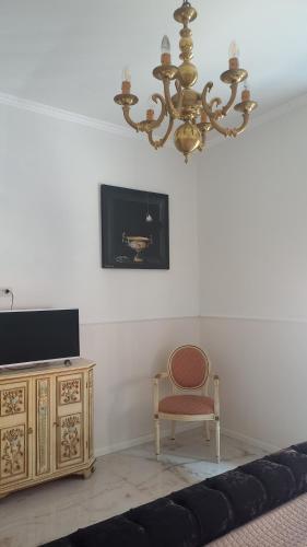 a living room with a chandelier and a chair at PALAZZO NOVECENTO Centro Storico in Lecco