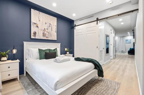 ein Schlafzimmer mit einem weißen Bett und blauen Wänden in der Unterkunft SWJ G - Save on 2Day or more Stays 25min to Times Sq in New York