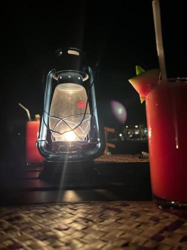 a lantern sitting on top of a table with a drink at Ranakeliya Lodge - Yala in Yala