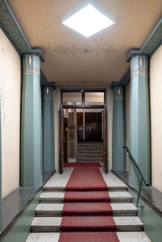 a hallway with a red carpet and a stair case at Scandic Primo Apartments - Eerikinkatu 46m2 in Helsinki