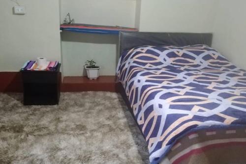 een slaapkamer met een bed met een blauw en wit dekbed bij Casa de Campo-Hospedaje Munay Wasi in Tarma