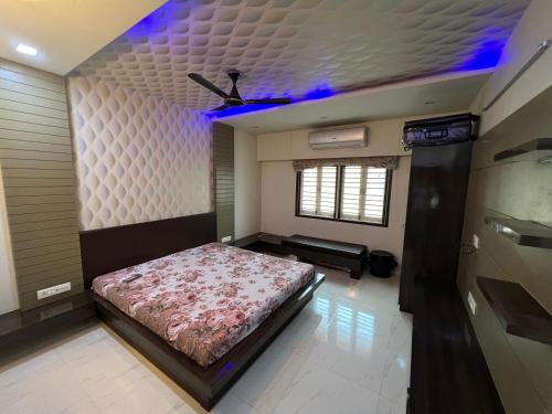 1 dormitorio con cama y techo con luces moradas en Home away from home! en Anand