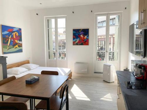 salon z łóżkiem i stołem w obiekcie Vue sur la place des Halles, Art Apparts w Béziers