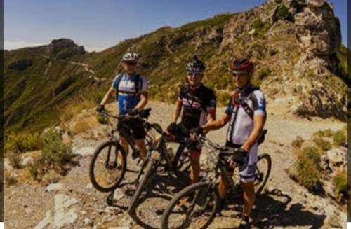 three people riding bikes on a mountain trail at Casa Tropical, serene poolside retreat in nature in Albox
