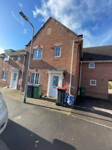 a brick house with two trash cans and a street light at 5 Holborn Spacious Home in Redhill