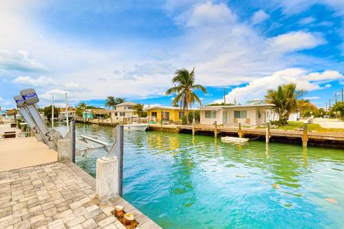 a river with a dock and houses and palm trees at La Pirata in Marathon