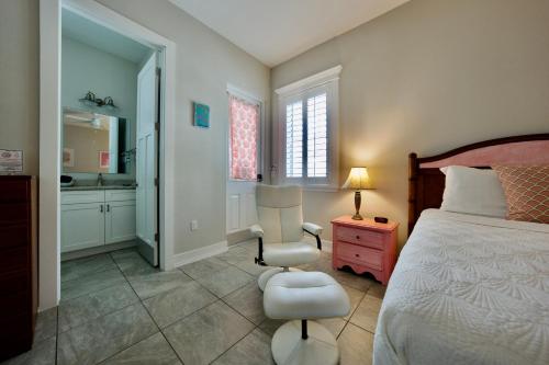 a bedroom with a bed and a chair and a table at Sunny Side Cottages in Dunedin