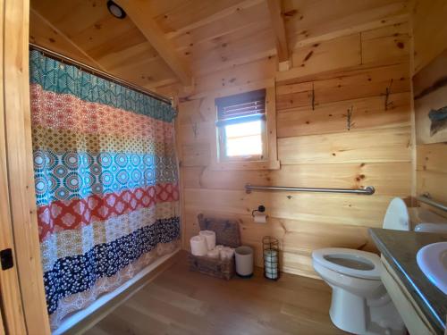 a bathroom with a toilet in a log cabin at Juneberry Ridge in Norwood