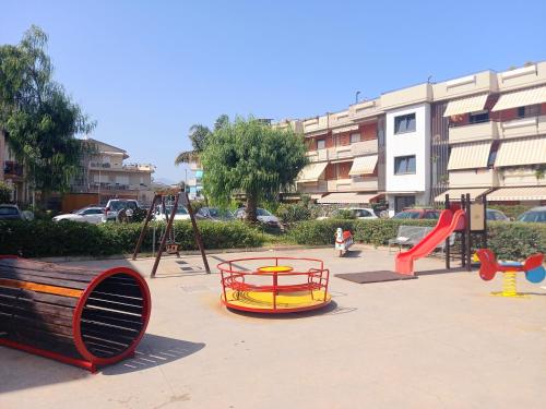 einen Spielplatz mit Rutsche und Schaukel in der Unterkunft Blu Corallo in Mascali