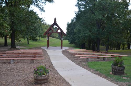 a group of benches in a park with a wooden arch at Lone Star w/ gametable in Ridgedale