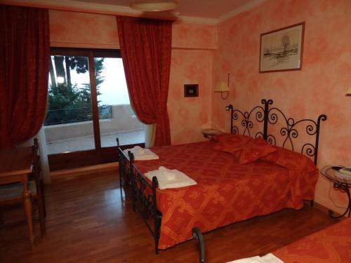 a bedroom with a bed with red sheets and a window at Hotel Internazionale in Ancona