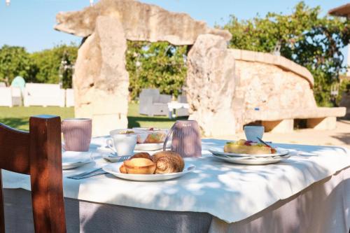 a table with plates of food on top at Agriturismo Il Megalite in Giurdignano
