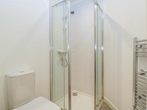 a bathroom with a toilet and a glass shower at Deers Leap in Lydney