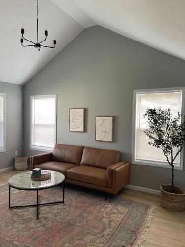 a living room with a brown couch and a table at Birdie Mae - 2 bedroom House in DT Hamilton in Hamilton