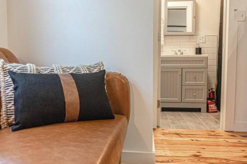 a brown couch in a room with a sink at Double The Fun II Two Houses and fire pit in shared yard in Kingston