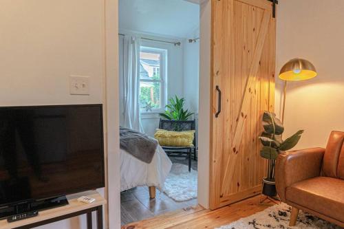 a living room with a television and a door to a bedroom at Double The Fun II Two Houses and fire pit in shared yard in Kingston